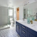 Modern bathroom interior with blue double vanity and glass shower | Raider Flooring