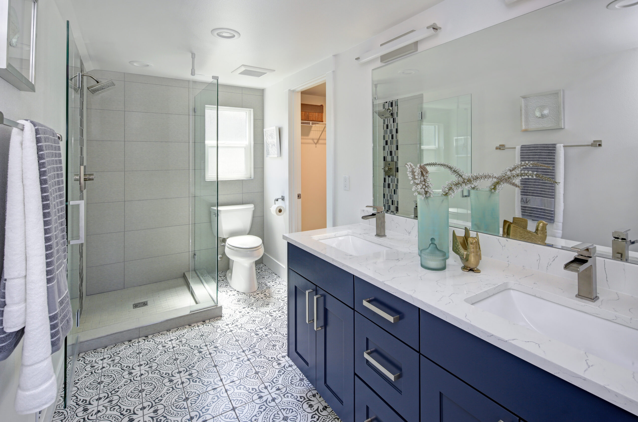 Modern bathroom interior with blue double vanity and glass shower | Raider Flooring