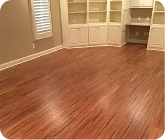 Reddish-brown hardwood or strand-woven bamboo planks installed in a traditional running bond pattern