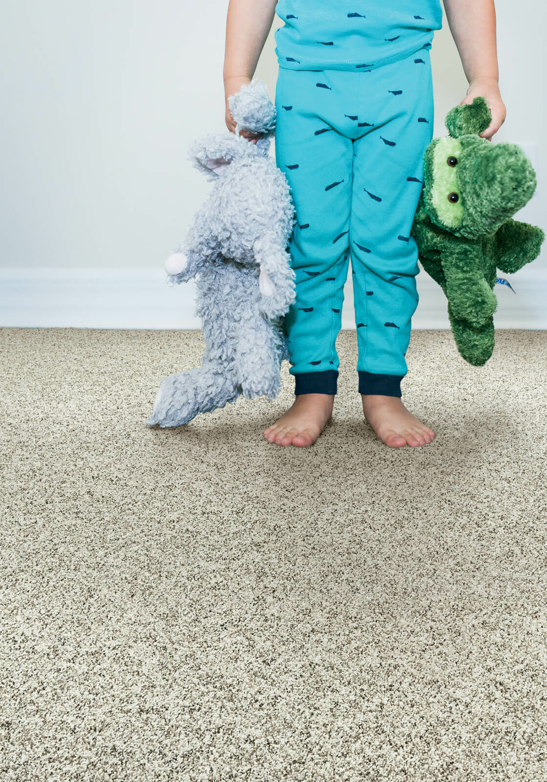 Kid with toys standing on soft carpet