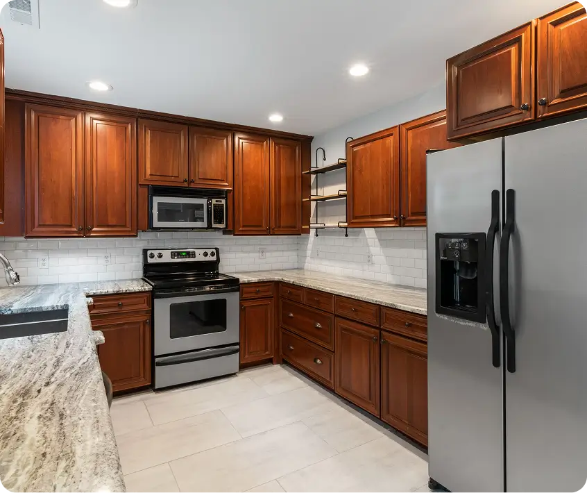 kitchen featuring rich wooden cabinets, stainless steel appliances, and light granite countertops
